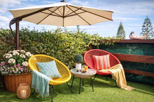 two chairs and a table with an umbrella at dream tiny house & luxury tent in Chania