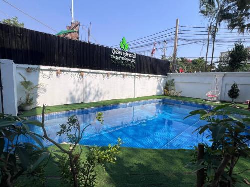 a swimming pool in a yard next to a building at Leaf Boutique SR in Siem Reap