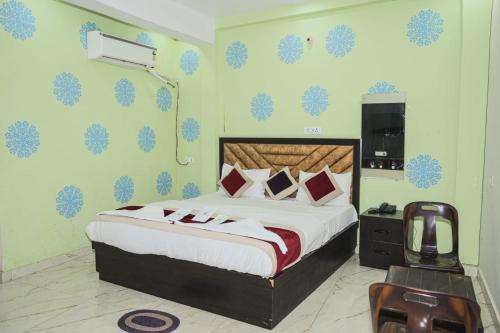 a bedroom with a king sized bed and a television at Hotel Ayodhya in Ayodhya