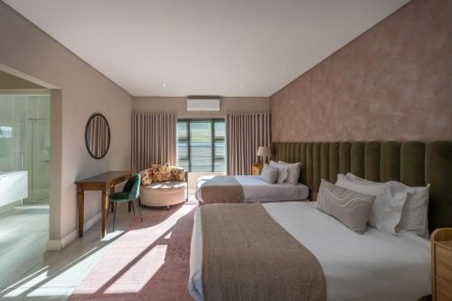 a hotel room with two beds and a desk at Khaya Elihle Guest House in Hazyview
