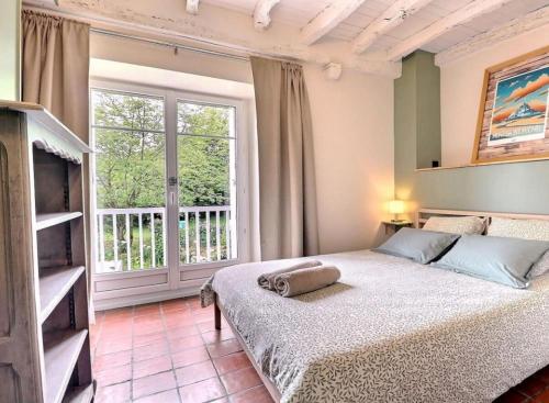 a bedroom with a bed and a large window at Maison d'hôtes KerCalow, Chambres d'hôtes in Pleine-Fougères