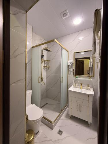 a bathroom with a shower and a toilet and a sink at GUZAL Boutique Hotel in Bukhara