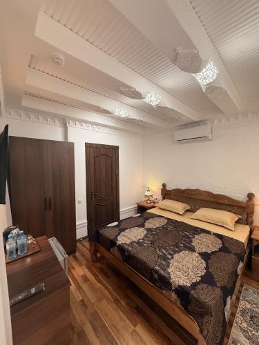 a bedroom with a large bed and a wooden floor at GUZAL Boutique Hotel in Bukhara
