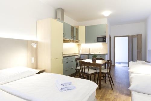 a room with two beds and a kitchen with a table at Studia a apartmány U Karla in Turnov