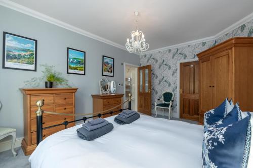 a bedroom with a large white bed with a chandelier at Snowdonia View in Llanfairpwllgwyngyll
