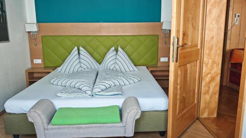 a small bed with a green headboard and a chair at Vintage Apartment in Graz