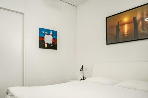 a bedroom with two white beds and a flat screen tv at Windshouse 2 Apartments in Nago-Torbole