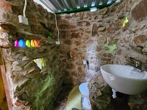 a stone bathroom with a sink and a toilet at Ubuntu Backpackers in Umtali