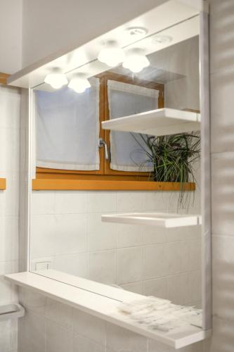 a bathroom with a mirror and a sink at Windshouse 2 Apartments in Nago-Torbole