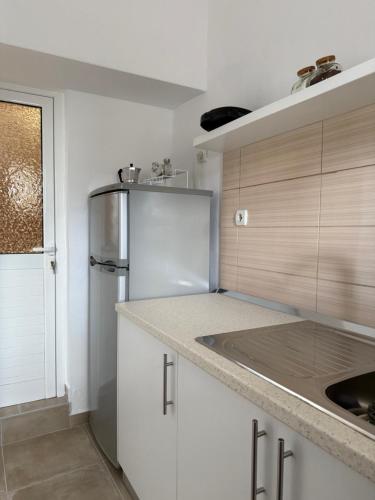 WHITE STUDIOS في هيماري: مطبخ بخزائن بيضاء وثلاجة من الفولاذ المقاوم للصدأ