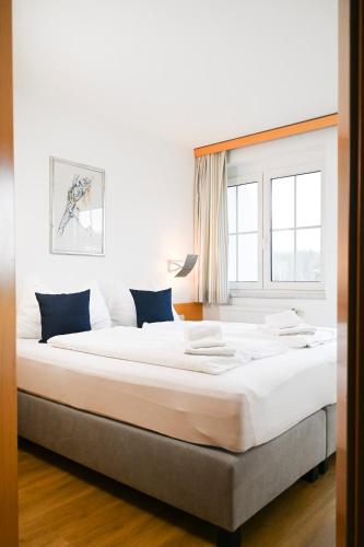 a large white bed in a room with a window at Maltschacher Seewirt in Feldkirchen in Kärnten