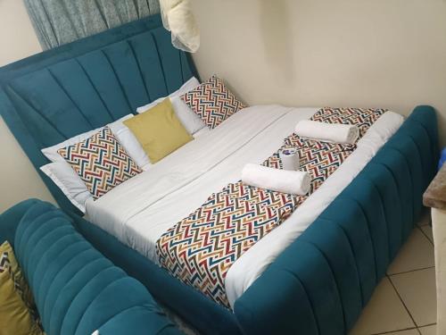 a blue bed with pillows on it in a room at Soney Homes in Nairobi