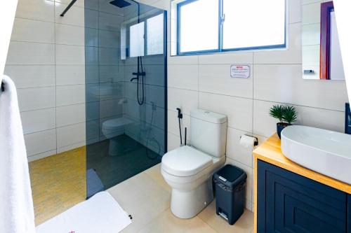a bathroom with a toilet and a sink and a shower at Elle Apartments in Lusaka