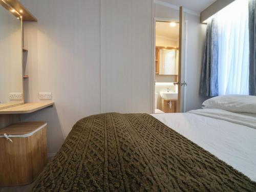 a bedroom with a large bed and a sink at Lodge 22, Moselle in Malton