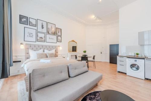 a white bedroom with a bed and a couch at Prenzlauer Berg Prestige in Berlin