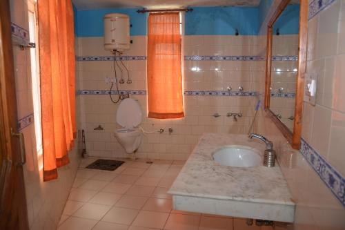 un bagno con lavandino e WC di AbodeHome Cottage a Manāli
