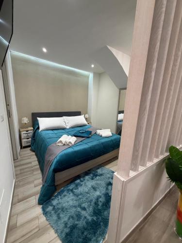 a bedroom with a bed with blue sheets and pillows at Spataro Home in Catania