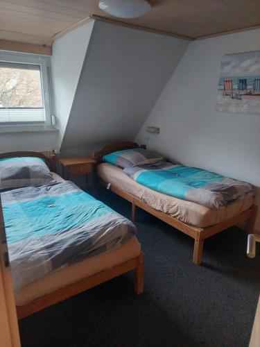 two twin beds in a room with a window at Ferienwohnung Haske mit Wallbox in Gifhorn