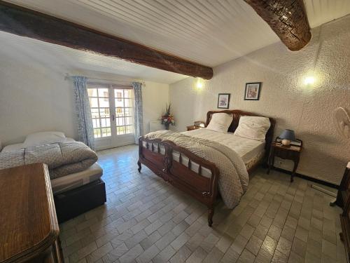 a bedroom with two beds and a window at La maison du vigneron 7 personnes, proche plage avec clim in Fitou