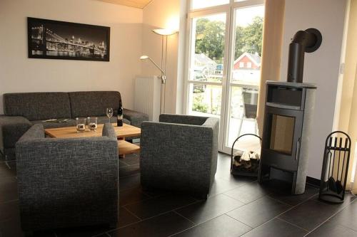 a living room with a couch and a wood stove at Ferienhaus Grafschafter Perle in Nordhorn