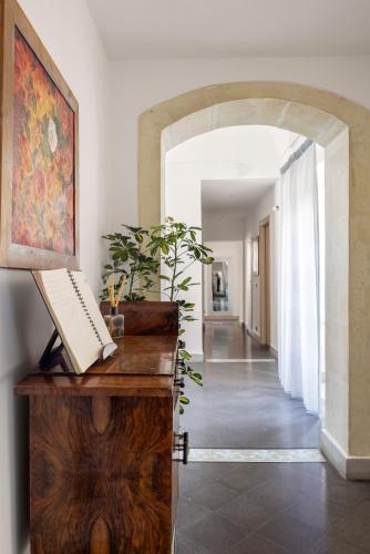 a hallway with an archway and a desk with a keyboard at Archimede Charm B&B - Historical Palace in Ortigia in Syracuse