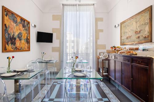 a dining room with a glass table and chairs at Archimede Charm B&B - Historical Palace in Ortigia in Syracuse
