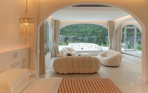 a bedroom with two white ottomans in front of a large window at Yangshuo MINOS Hotel-Inspired by Santorini design, Entrance of Ten-Mile Gallery,Free Laundry,Itinerary Hepler,Book Tickets in Advance,E Scooter Service in Yangshuo