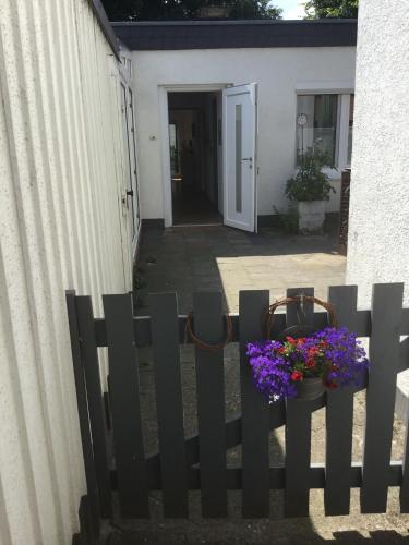 a black fence with flowers on it next to a building at Dorle`s Huus in Nordhorn