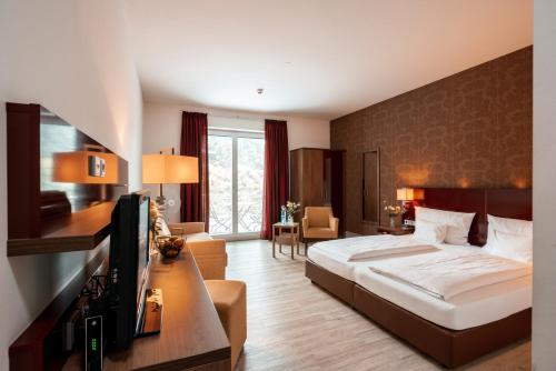 a hotel room with a bed and a television at Weinhotel Wasem in Ingelheim am Rhein