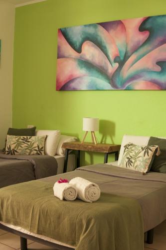 a room with two beds with towels and a painting on the wall at The Tree House Tenerife in El Médano