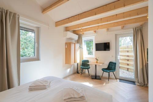 a bedroom with a bed and a table and chairs at Studio Oak & Studio Linde in Aerdenhout