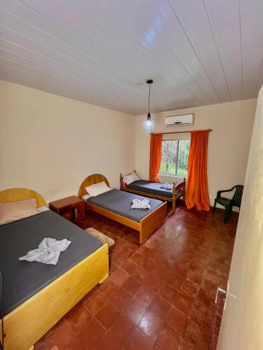 une chambre avec deux lits et une fenêtre dans l'établissement Quinta El Edén Studenko, à Encarnación