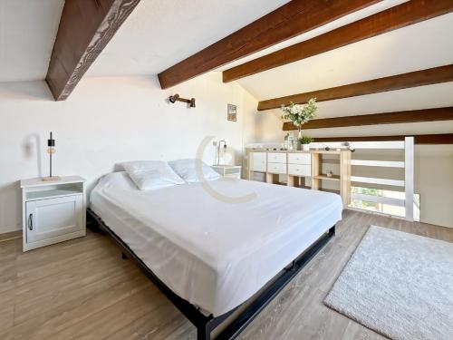 a bedroom with a large white bed in a room at Duplex T2 - Madonna di a Sarra in Calvi