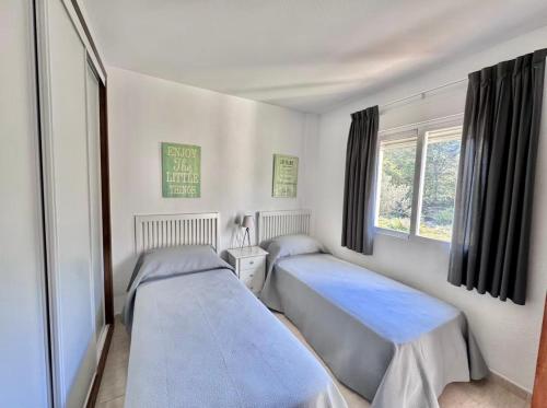 two beds in a room with a window at Bellaluz 18-16 La Manga Club in Atamaría