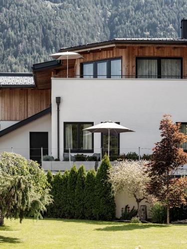 a house with an umbrella in front of it at MYALPS Ötztal inklusive Spa- Area in Umhausen