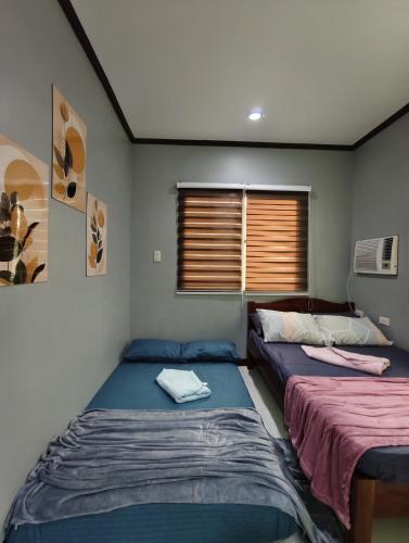 a room with two beds and a window at Aquino Stays in Luna