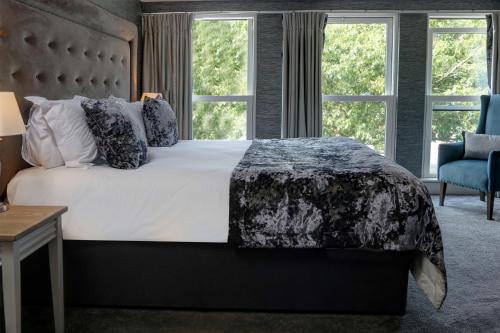 a bedroom with a large bed and two windows at The Lord Street Hotel; BW Signature Collection in Southport