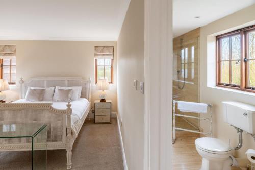 a white bedroom with a bed and a toilet at Tuffon Hall Farmhouse 10 in Sible Hedingham