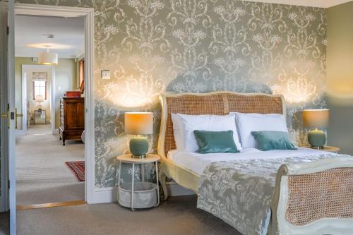 a bedroom with a bed and a wall with wallpaper at Tuffon Hall Farmhouse 10 in Sible Hedingham
