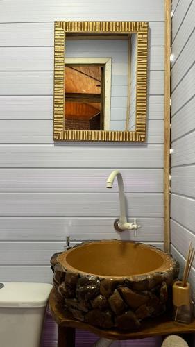 a bathroom with a stone sink and a mirror at Studio Rústico - Refúgio Arara Azul in Urubici