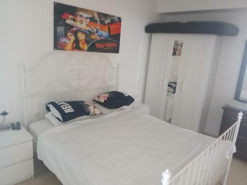 a white bed with two pillows on top of it at מרינה טוורס מלון בוטיק in Herzliya B