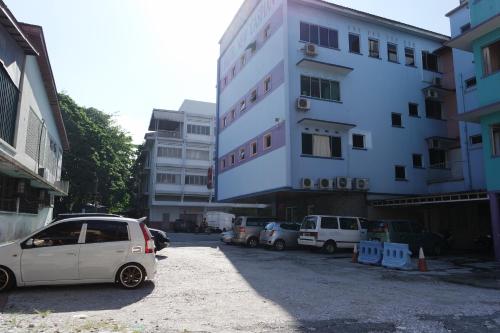 a white car parked in front of a building at New Caspian Hotel in Ipoh