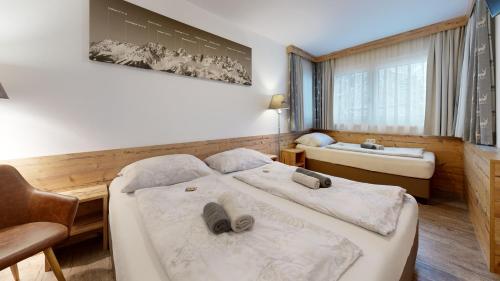 a hotel room with two beds and a sink at Pension Rainer in Ellmau