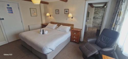 a bedroom with a bed and a blue chair at Trehellas House Hotel & Courthouse restaurant in Bodmin