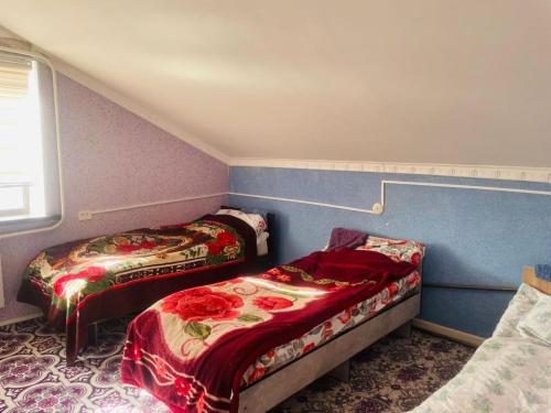 a small room with two beds and a window at Nurislam GuestHouse in At-Bashy