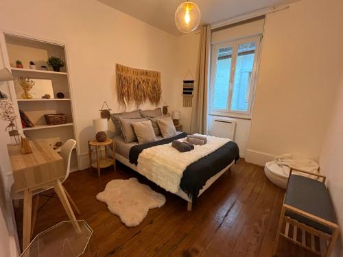 a bedroom with a bed and a desk and a window at Le Petit Millésime - Homillesime in Dijon