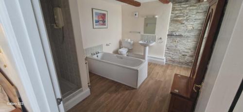 a bathroom with a tub and a toilet and a sink at Trehellas House Hotel & Courthouse restaurant in Bodmin