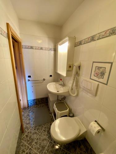 a small bathroom with a toilet and a sink at La Perla di Pera in Pera
