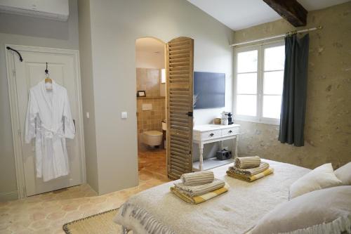 a bedroom with a bed and a bathroom with a mirror at Plates Luxury Farm House Chambres d'hôtes et gîte in Saint-Mézard