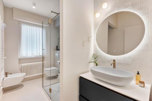 a white bathroom with a sink and a mirror at Magnolia Studio Appartamento Marina di Carrara in Marina di Carrara